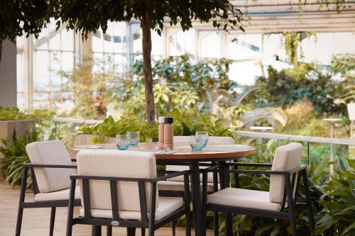 a wooden table and chairs on a patio at Paragraph Resort & Spa Shekvetili, Autograph Collection in Shekvetili