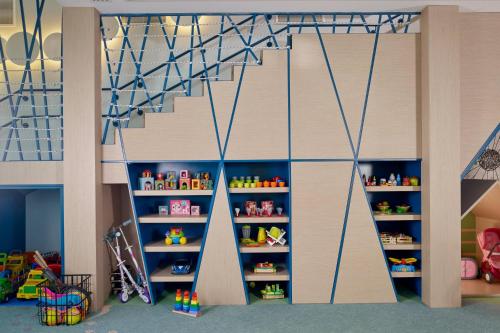a room with a wall with shelves with toys at Paragraph Resort & Spa Shekvetili, Autograph Collection in Shekvetili