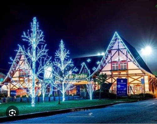 カンポス・ド・ジョルドンにあるCasa para temporadaのクリスマスライトが目の前にある大きな建物