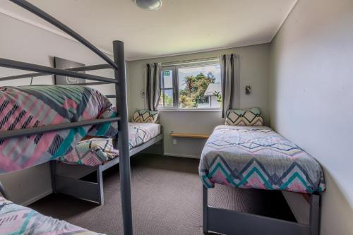 a room with two bunk beds and a window at Ivorytowers Accommodation in Fox Glacier
