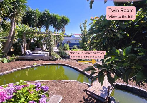 a garden with a small pond in the middle at Tairua Garden Hideaway - Homestay with Private Room in Tairua