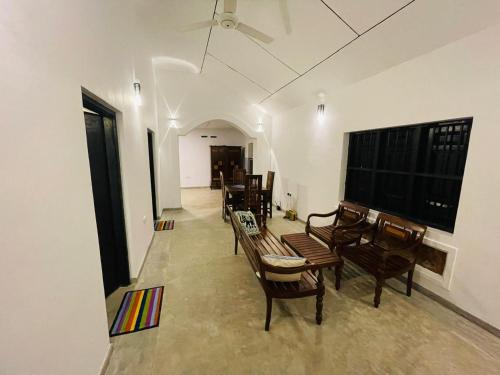 Una sala de estar con sillas, una mesa y un televisor. en Berg House Mirissa, en Mirissa