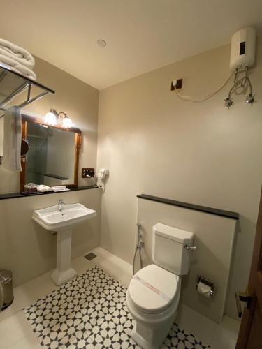 a bathroom with a toilet and a sink at Amritha Heritage in Trivandrum