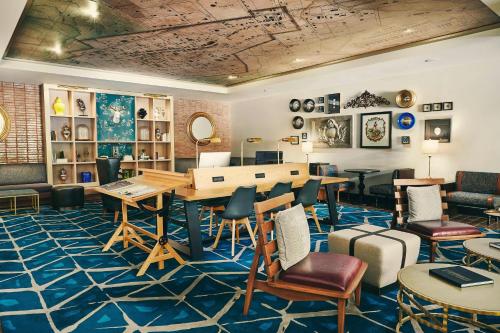 a room with a desk and chairs and a table at The Draftsman, Autograph Collection in Charlottesville