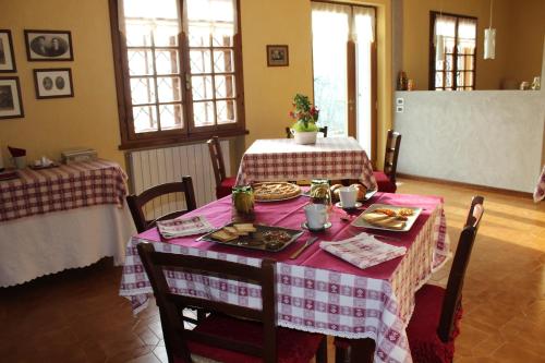 uma sala de jantar com uma mesa com uma toalha de mesa rosa em La Quercia em Badia Calavena