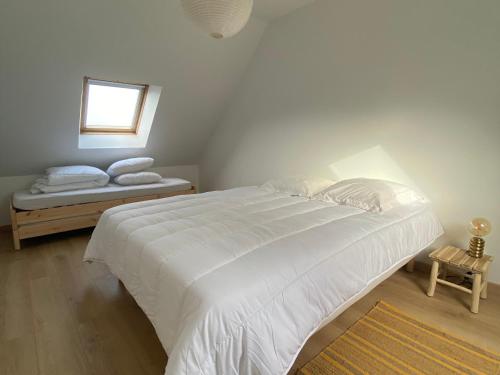 a bedroom with a large white bed and a window at Charmante maison proche plage à Groix, 2 chambres - FR-1-813-3 in Groix