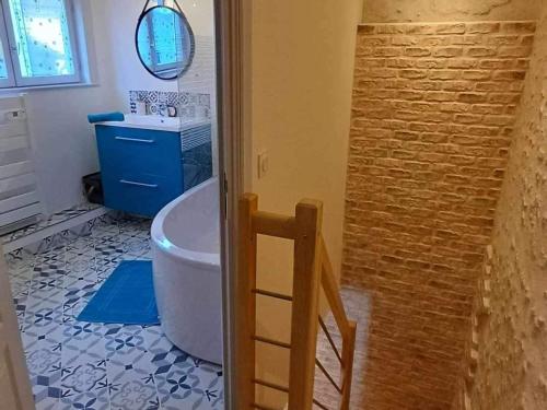 a bathroom with a tub and a toilet and a sink at Maison cosy proche Loire avec climatisation - FR-1-590-531 in Beaugency