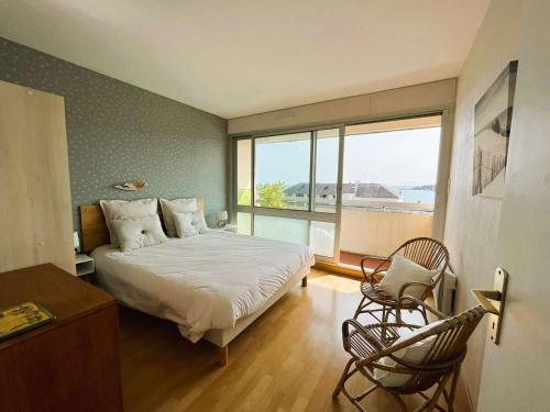 a bedroom with a bed and a large window at Appartement Bénodet 4 pers, proche plage - FR-1-481-169 in Bénodet