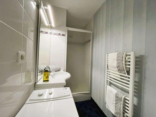 a white bathroom with a sink and a mirror at Appartement Bénodet 4 pers, proche plage - FR-1-481-169 in Bénodet