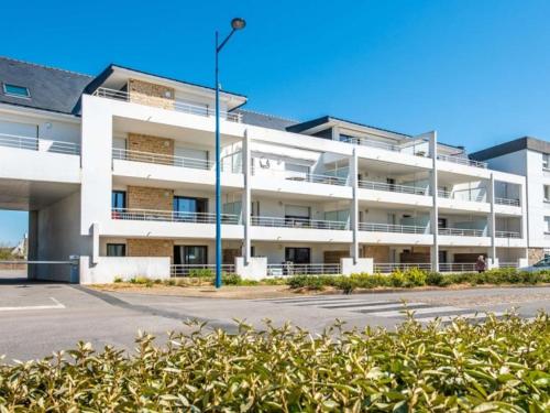 un parking vide devant un bâtiment blanc dans l'établissement Etel : Appartement 2P 42m², balcon, parking, proche plage, animaux admis - FR-1-479-189, à Étel