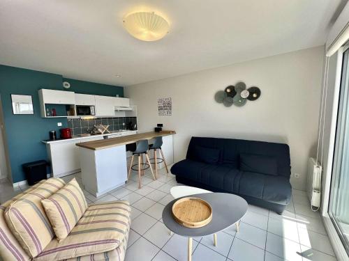 un salon avec un canapé et une table dans l'établissement Étel - Appart 42m² - 2 pièces, Wifi, Parking, à 450m du centre et 750m des plages - FR-1-479-196, à Étel