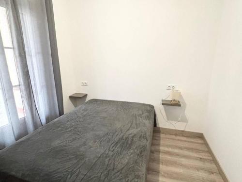 Ce lit se trouve dans un dortoir blanc doté d'une grande fenêtre. dans l'établissement F2 meublé avec balcon, clim, WIFI, animaux admis - 50m des thermes - FR-1-703-198, à Amélie-les-Bains-Palalda