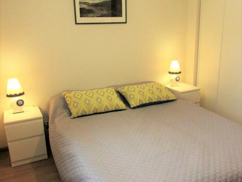 a bedroom with a bed with two pillows on it at Charmant T2 à Étel avec terrasse, parking et proche plage - FR-1-479-194 in Étel