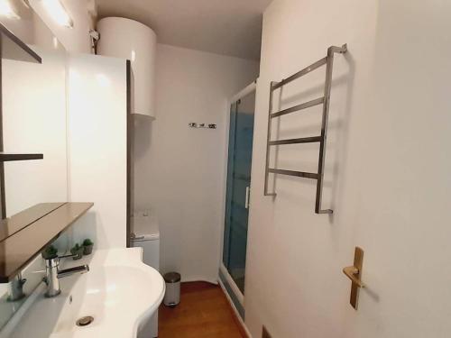 La salle de bains est pourvue d'un lavabo et d'une échelle de serviettes. dans l'établissement Appartement rénové 3 pièces avec parking et clim, proche plage - FR-1-782-72, au Barcarès