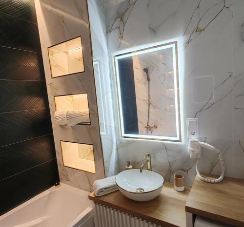 Un baño con lavabo, bañera y espejo. en Apartament Gold Luxury 3, en Baia Mare