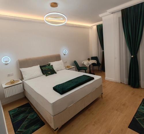 1 dormitorio con 1 cama blanca grande con detalles verdes en Apartament Gold Luxury 3, en Baia Mare