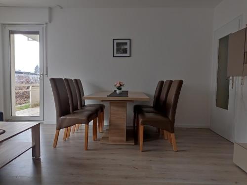 a dining room with a table and four chairs at Work and stay IaM 90 qm 3 Schlafzimmer 6 betten mit Balkon und kraftraum in Plettenberg