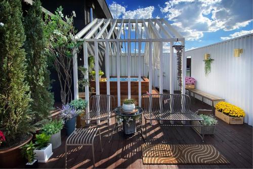 a patio with two chairs and a canopy with plants at Hotel Voll in Seoul
