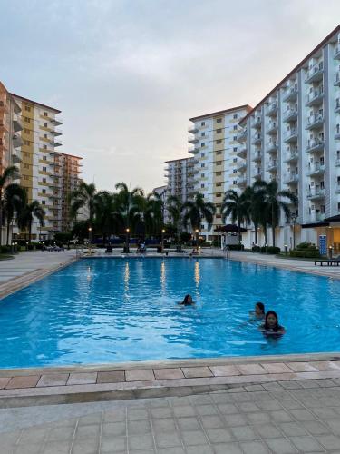 people swimming in a swimming pool in a hotel at Staycation by Estelle in Manila