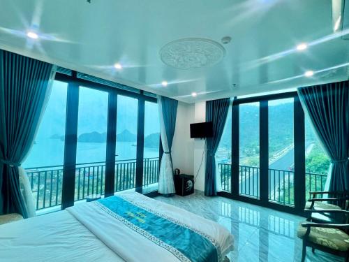 a bedroom with a bed and large windows at View Point - Anh Quan in Cat Ba