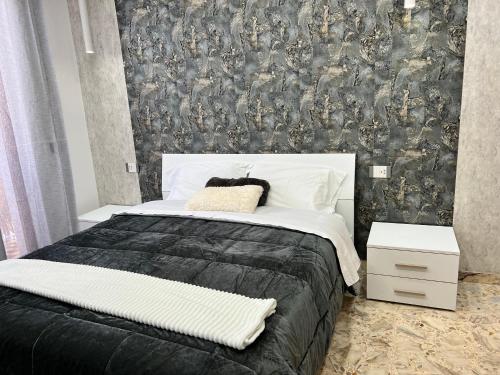 a bedroom with a bed with a black and white comforter at Pompei Sunday Estate Exclusive Apartaments in Pompei