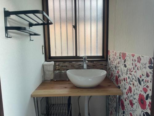 a bathroom with a bowl sink on a wooden counter at Hakuna Matata in Minamiawaji