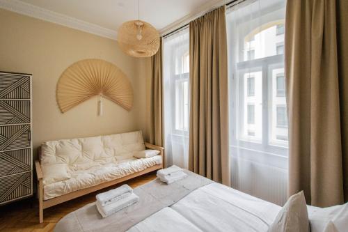 a bedroom with a white bed and a large window at Radost Residence The Heart of Unique Living in Prague