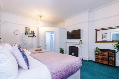 a bedroom with two beds and a fireplace at Victoria Park Studio 6 - Mins Walk To Train Station, Free Parking, Free Netflix, Prime & Disney in Leamington Spa