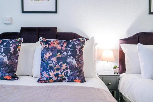 two beds in a room with two pillows on them at Victoria Park Studio 6 - Mins Walk To Train Station, Free Parking, Free Netflix, Prime & Disney in Leamington Spa