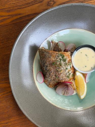 a plate with a piece of fish with a side of dipping sauce at Tango Luxe Beach Villa, Koh Samui in Choeng Mon Beach