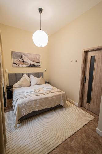 a bedroom with a bed and a chandelier at Radost Residence The Heart of Unique Living in Prague