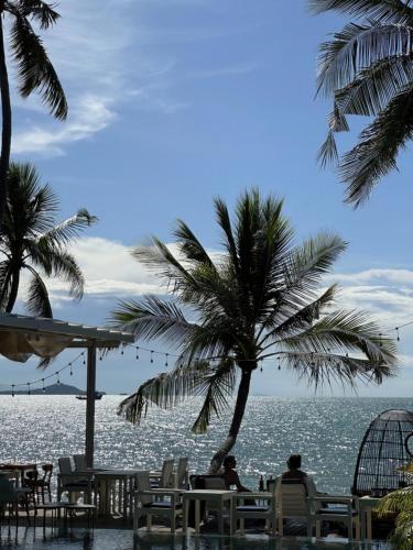 a view of the ocean from a beach with palm trees at Tango Luxe Beach Villa, Koh Samui in Choeng Mon Beach