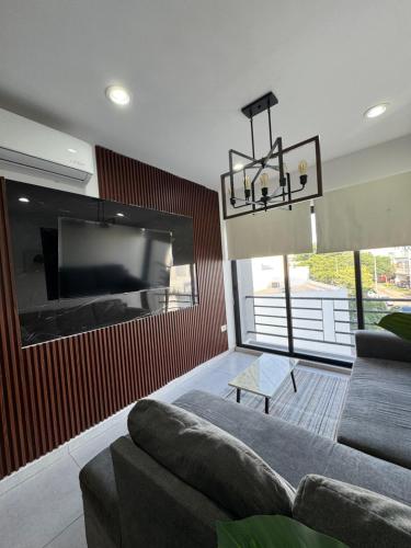 a living room with a couch and a flat screen tv at Departamento moderno in Culiacán