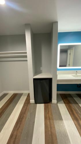 an empty room with a sink and a mirror at Plaza Inn Motel - Los Angeles area in Rosemead