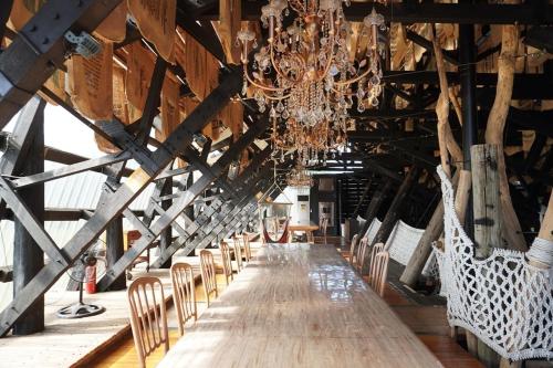 a long table in a barn with chairs and a chandelier at 橘舍三食OrangeFarmerlife in Miaoli