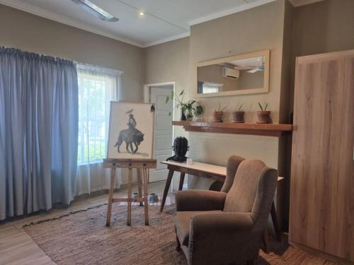 a living room with a desk and a chair at Piece of Parys in Parys
