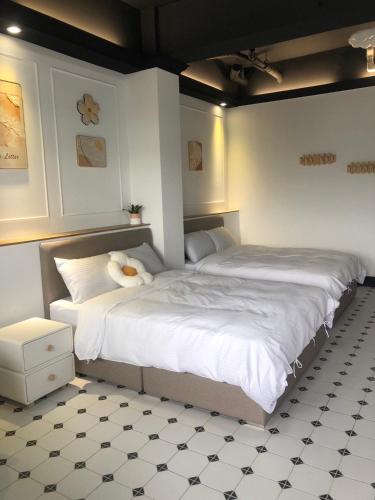 Un dormitorio con dos camas con sábanas blancas. en Stroll at Wudao Inn, en Ch'ien-p'u