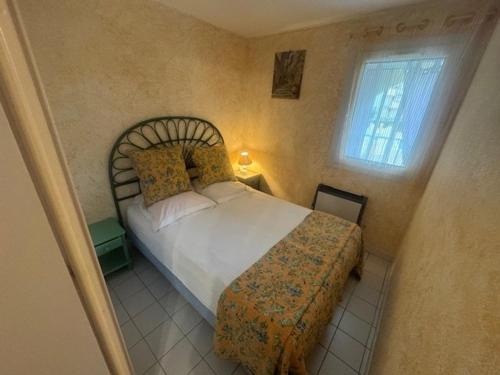 une chambre avec un lit et une fenêtre dans l'établissement Appartement T2 Cabine, piscine, parking, près plage Cap d'Agde - FR-1-749-76, au Cap d'Agde