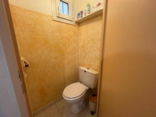 Elle comprend une petite salle de bains pourvue de toilettes et d'une fenêtre. dans l'établissement Appartement T2 Cabine, piscine, parking, près plage Cap d'Agde - FR-1-749-76, au Cap d'Agde