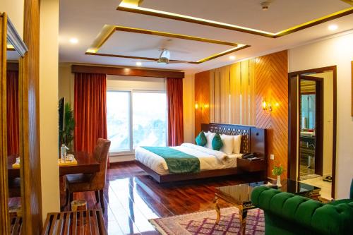 Un dormitorio con una cama y una ventana grande. en Hotel Tourmaline Peshawar, en Peshawar
