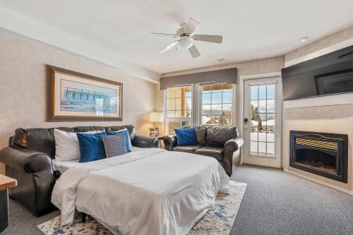 1 dormitorio con cama, sofá y chimenea en Vista, en Fairmont Hot Springs