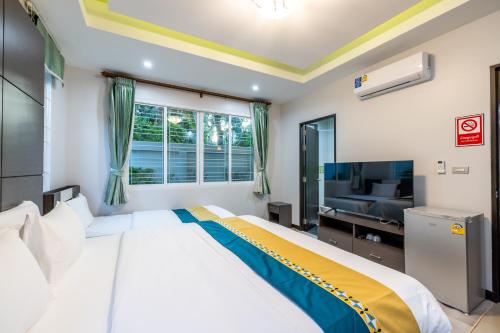 a bedroom with a large bed and a window at Kana Hotel Phuket普吉岛卡娜酒店 in Rawai Beach