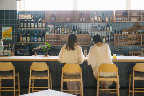 two women sitting at a counter in a bar at métisse stay in Nanto