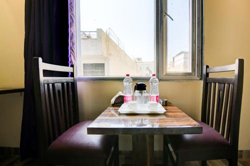 a table with a coffee maker on it in front of a window at Hotel Smart Signature in New Delhi
