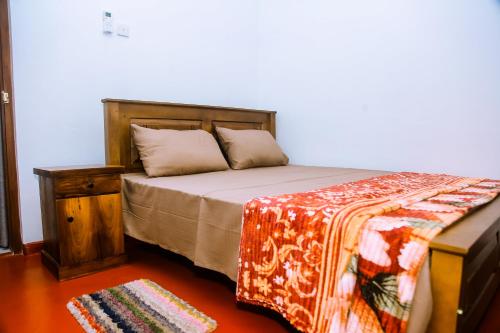 a bedroom with a bed with a wooden headboard and a rug at Villa Number 6 in Weligama