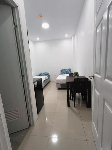 a room with a table and a bed and a door at Greenwood Residences in Bacolod