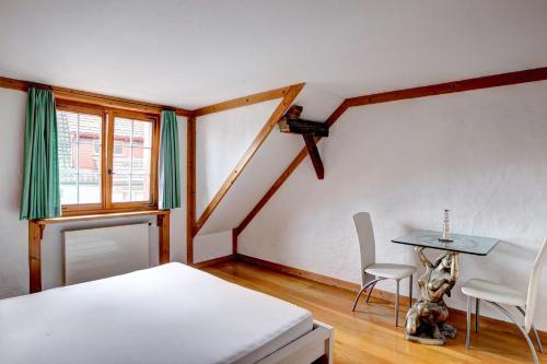 a bedroom with a bed and a table and chairs at Hotel Bären Amriswil in Amriswil
