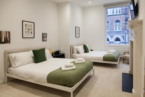 une chambre avec deux lits et une fenêtre dans l'établissement Grand Central Apartments - Perfect for Families - Contractors - Professionals, à Central Station