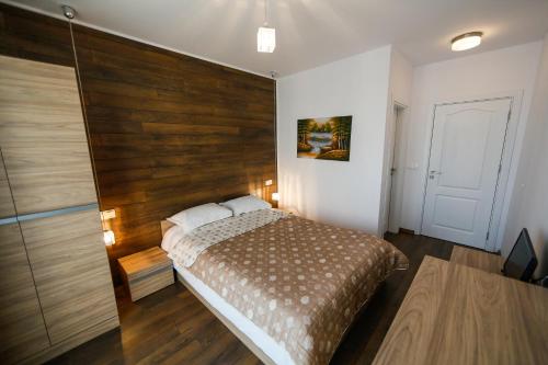 une chambre avec un lit avec une tête de lit en bois dans l'établissement Twin House, à Ognyanovo