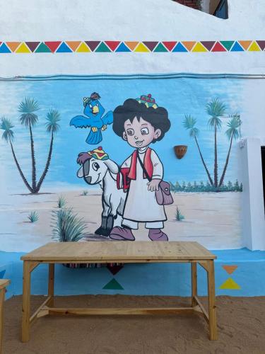 a mural of a girl and a goat on a table at Nukud guest house in Aswan